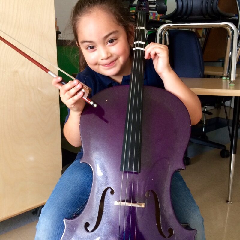 A young girl plays the cello